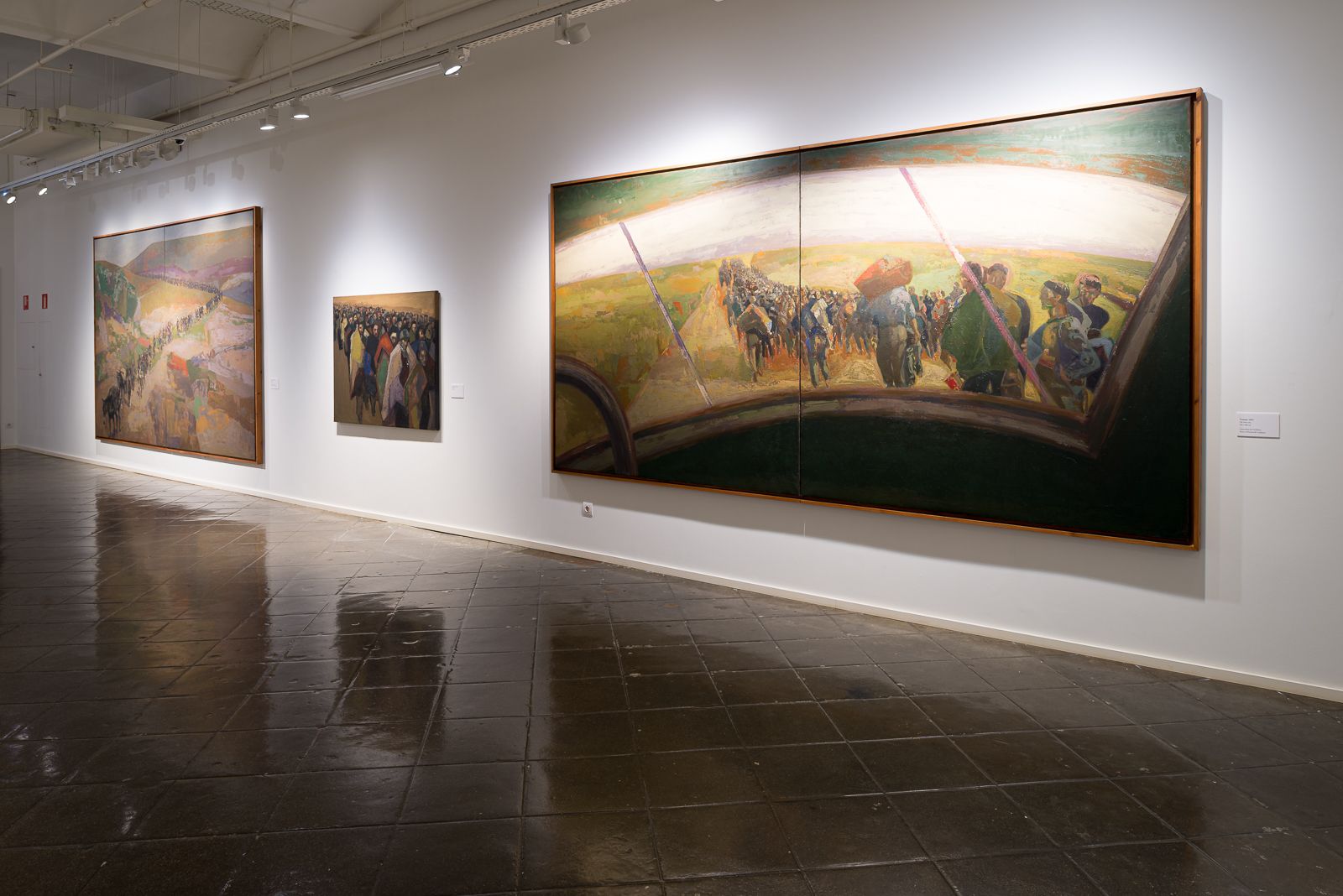 Grandes pinturas que representan escenas vibrantes de personas y paisajes se exhiben en las paredes de una galería.